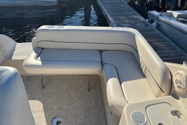 Slide: The Image of 2001 Crownline 242 CR boat interior with beige seating and dockside view. - 28