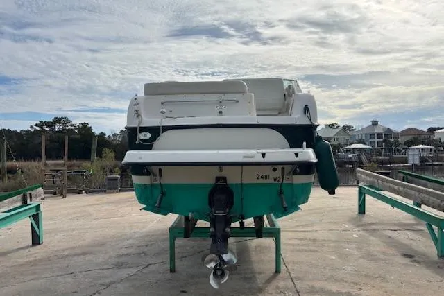 Slide: The Image of 2001 Crownline 242 CR boat on a dock, rear view, under a cloudy sky. - 6