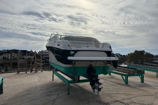 Slide: The Image of 2001 Crownline 242 CR boat on dry dock with scenic waterfront background. - 7
