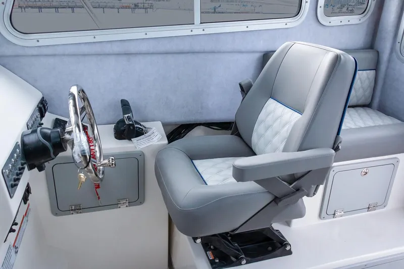Slide: The Image of Manufacturer Provided Image: Captain's seat and helm of 2025 Defiance Admiral 250 EX boat interior. - 3