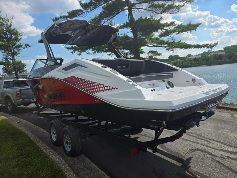 Slide: The Image of 2021 Scarab 285 ID boat on trailer by a lake, under a clear sky. - 1
