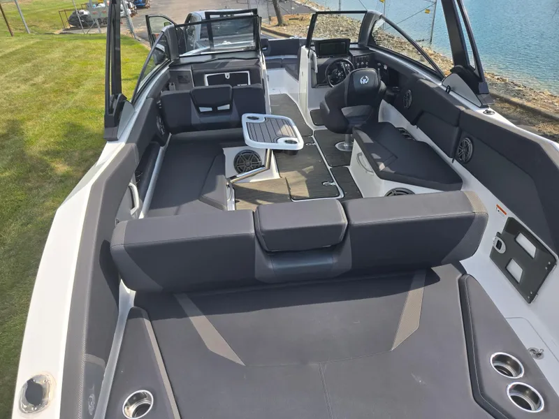 Slide: The Image of 2021 Scarab 285 ID boat interior with seating, table, and steering console by the water. - 11