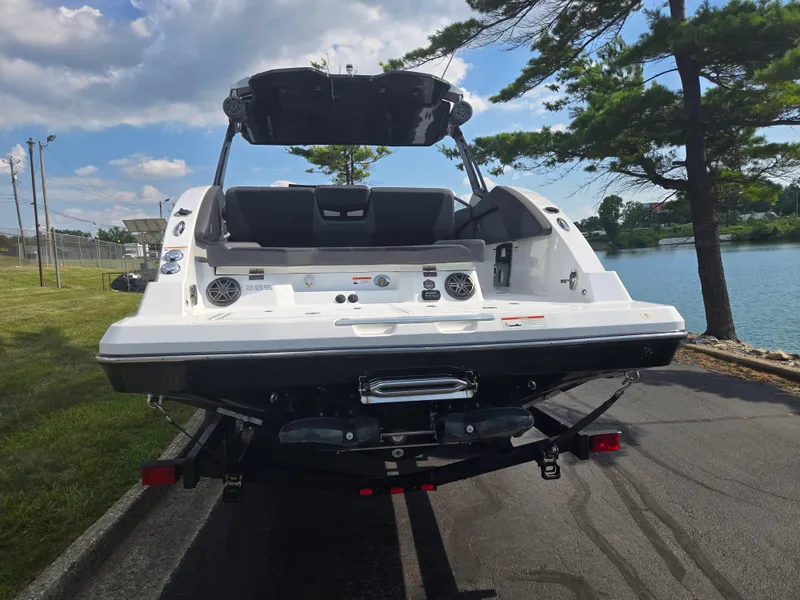 Slide: The Image of 2021 Scarab 285 ID boat on trailer by a lake, under a clear sky. - 2