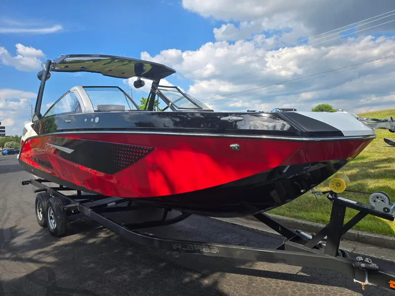 Slide: The Image of 2021 Scarab 285 ID boat on trailer, red and black design, under a blue sky. - 5