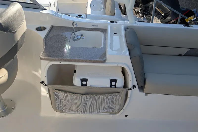Slide: The Image of 2026 Key West 239 DFS boat interior with sink, seating, and storage area. - 11