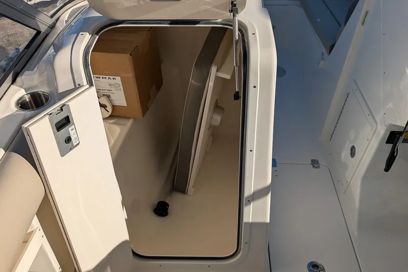 Slide: The Image of 2026 Key West 239 DFS boat storage compartment with open hatch and cardboard box inside. - 17