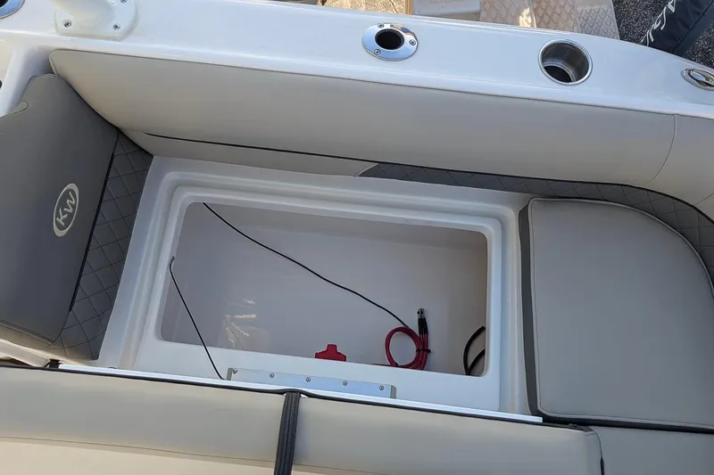 Slide: The Image of 2026 Key West 239 DFS boat storage compartment with cushioned seating and cup holders. - 8