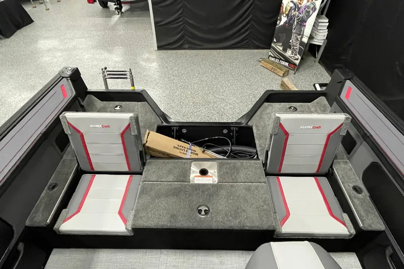 Slide: The Image of 2025 Alumacraft Trophy 175X Sport boat interior with gray and red seating. - 12