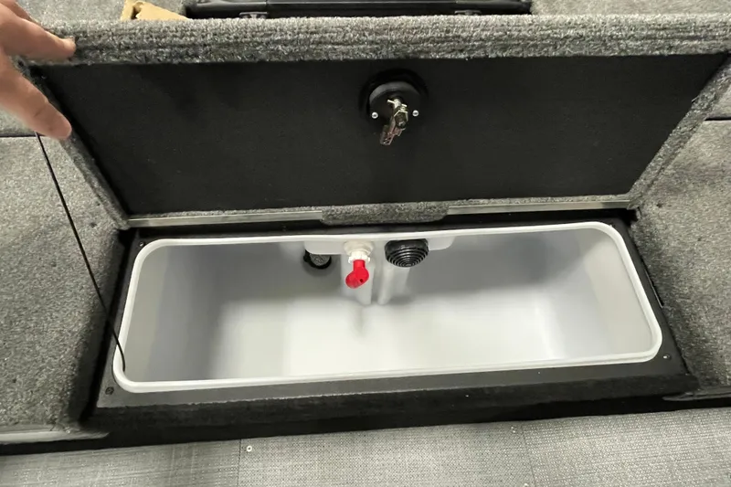 Slide: The Image of 2025 Alumacraft Trophy 175X Sport livewell compartment with open lid and visible plumbing. - 13