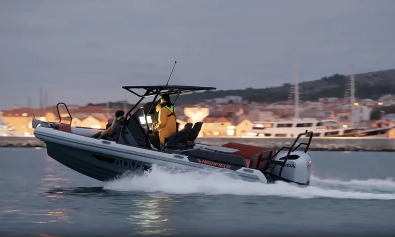 Slide: The Image of 2025 Highfield ADV7 boat cruising on water at dusk near a coastal town. - 8