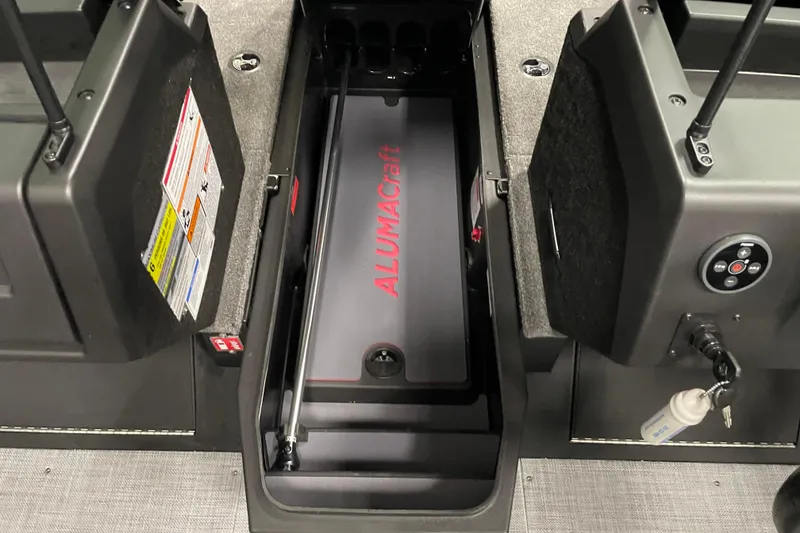 Slide: The Image of 2025 Alumacraft Trophy 185X Sport interior with storage compartment and control panel. - 5