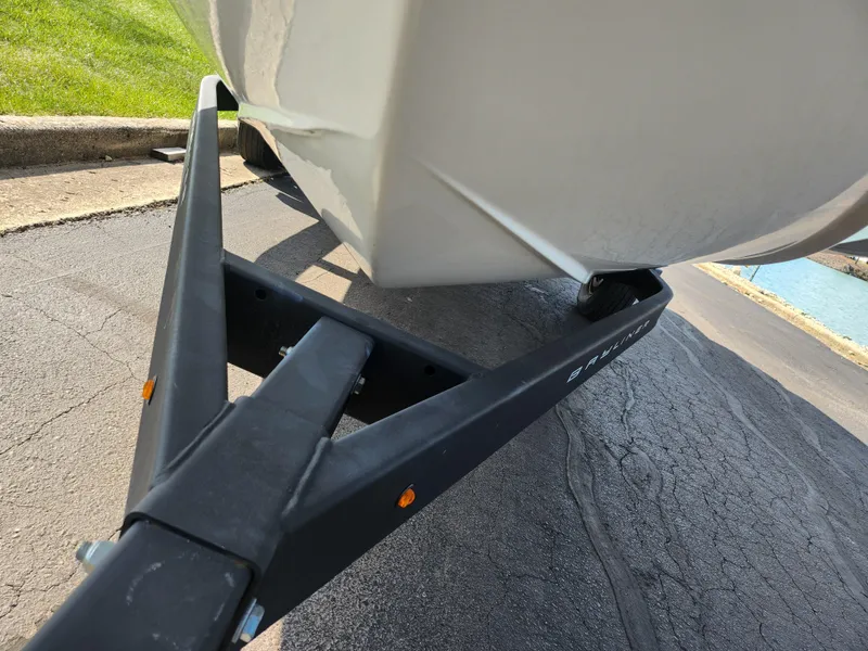 Slide: The Image of Bayliner DX 2000 boat trailer hitch, 2021 model, parked on asphalt near water. - 7
