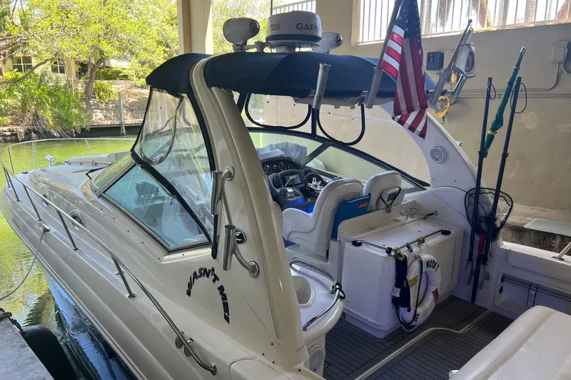 Slide: The Image of 2006 Sea Ray 340 Sundancer boat docked, featuring cockpit and American flag. - 5