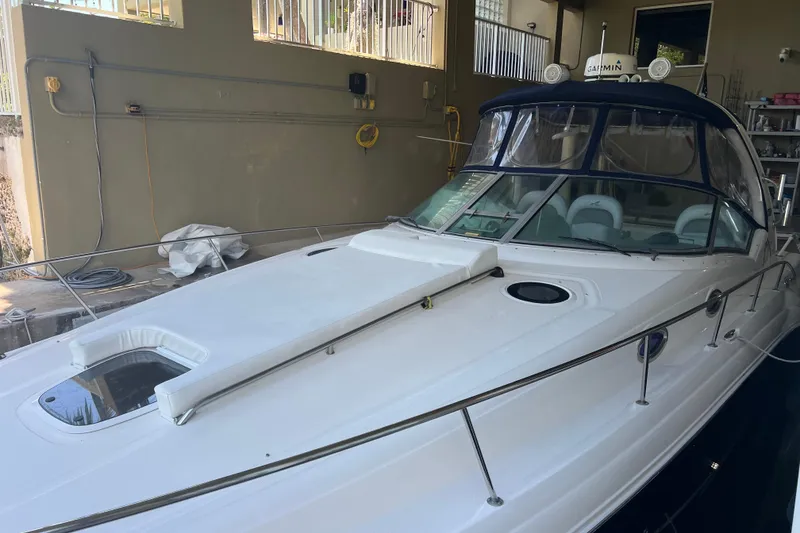 Slide: The Image of 2006 Sea Ray 340 Sundancer boat in a covered dock, featuring sleek design and modern amenities. - 6