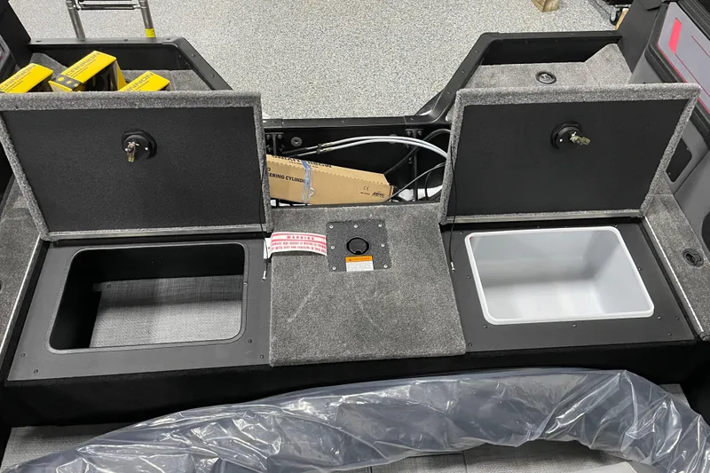Slide: The Image of 2025 Alumacraft Trophy 185X Sport boat storage compartments with open lids and interior view. - 13