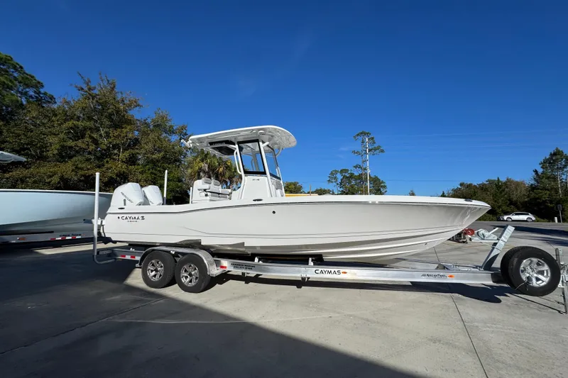 Slide: The Image of 2026 Caymas 281 HB boat on trailer, parked outdoors under clear blue sky. - 10