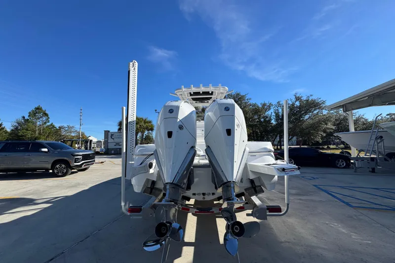 Slide: The Image of 2026 Caymas 281 HB boat with dual outboard motors in a parking lot. - 16