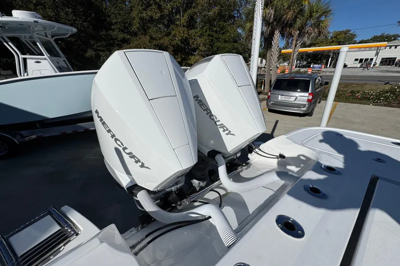 Slide: The Image of Twin Mercury outboard engines on a 2026 Caymas 281 HB boat, parked outdoors. - 41