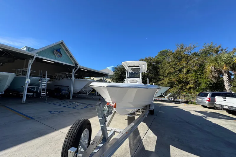 Slide: The Image of 2026 Caymas 281 HB boat on trailer at marina under clear blue sky. - 6