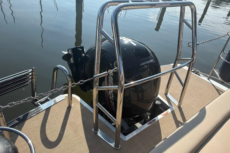 Slide: The Image of 2024 Harris HCX23 boat with Mercury outboard motor, docked on calm water. - 6