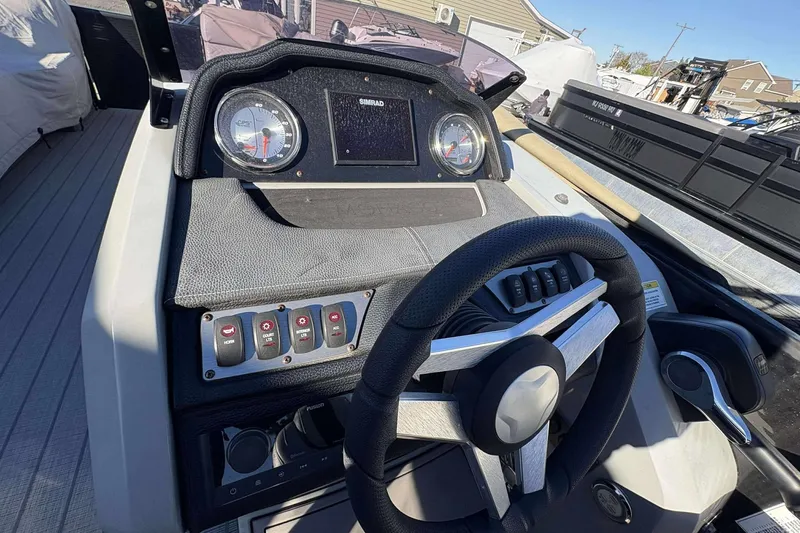 Slide: The Image of Dashboard of a 2020 Godfrey Monaco 25 boat with steering wheel and control panel. - 10