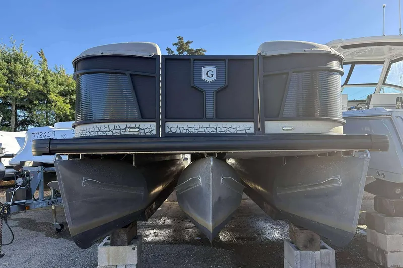 Slide: The Image of 2020 Godfrey Monaco 25 pontoon boat on blocks, front view, outdoors. - 14