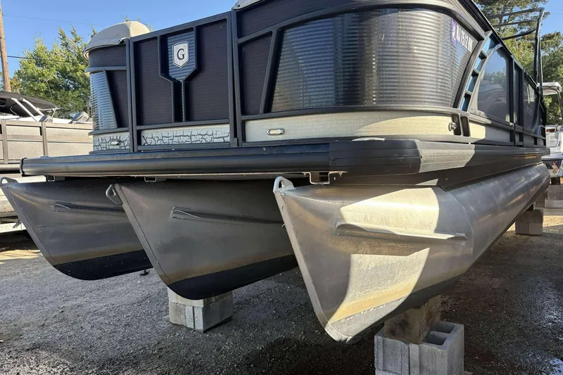 Slide: The Image of 2020 Godfrey Monaco 25 pontoon boat on blocks, showcasing aluminum pontoons and sleek design. - 3