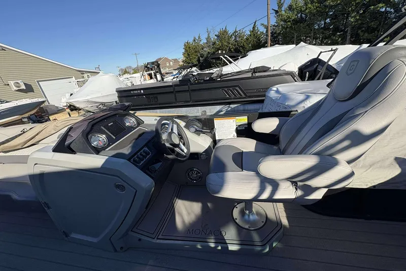 Slide: The Image of 2020 Godfrey Monaco 25 boat interior with steering wheel and captain's chair. - 4