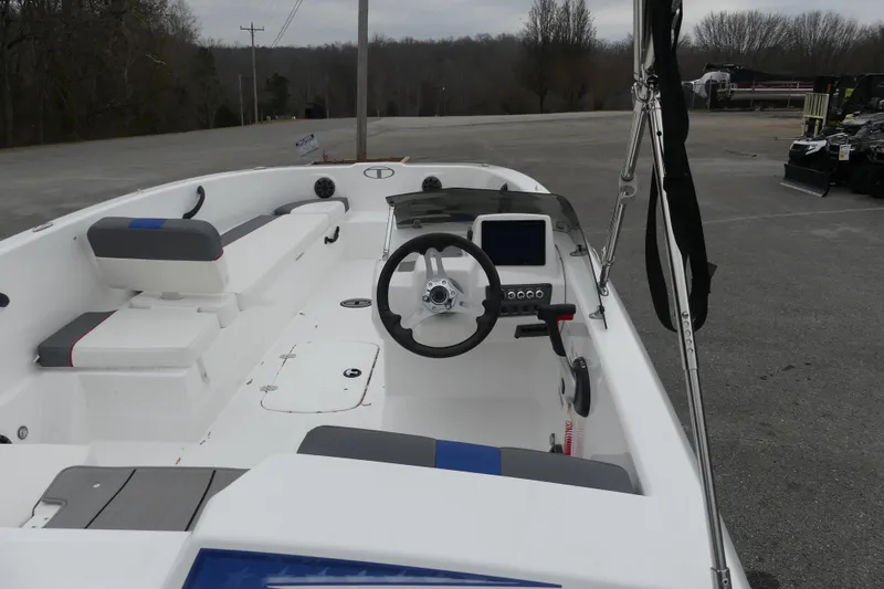 Slide: The Image of 2024 Tahoe T18 boat interior with steering wheel and seating, parked outdoors. - 4
