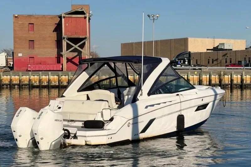 The Image of 2021 Cruisers Yachts 338 Outboard on serene water near coastal homes. - 0