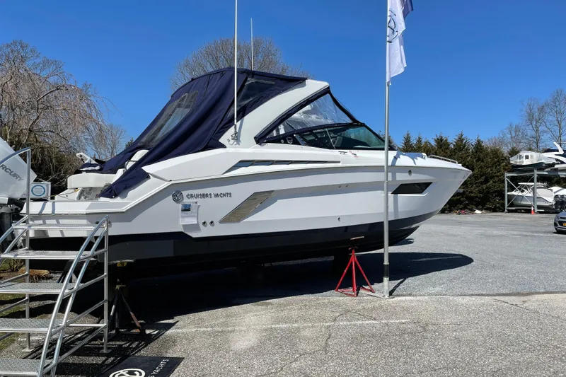 Slide: The Image of 2021 Cruisers Yachts 338 Outboard on display, parked outdoors under clear blue sky. - 8