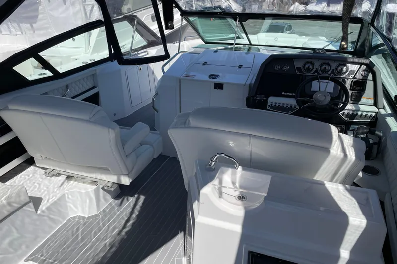 Slide: The Image of 2021 Cruisers Yachts 338 Outboard cockpit with white seating and modern dashboard. - 4
