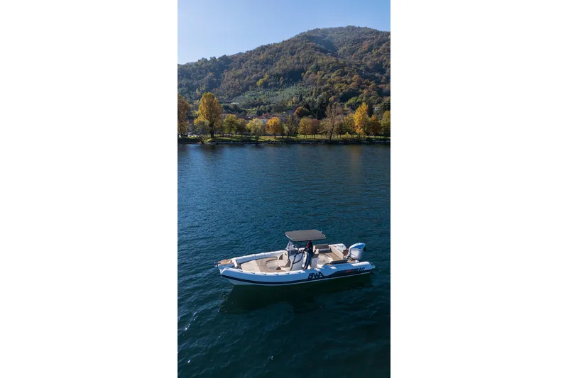Slide: The Image of 2026 BWA GTO 308 boat cruising on a serene lake with scenic mountain backdrop. - 10