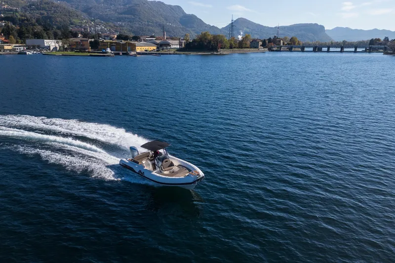 Slide: The Image of A 2026 BWA GTO 308 boat cruising on a scenic lake with mountains in the background. - 12