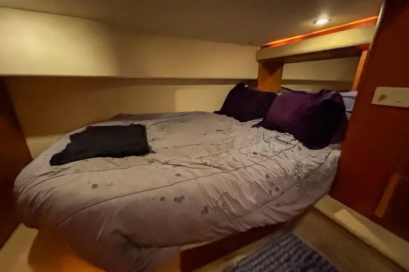 Slide: The Image of Cozy bedroom interior of 2003 Silverton 410 Sport Bridge yacht with plush bedding. - 102