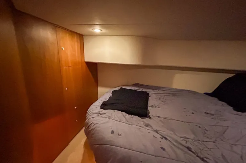 Slide: The Image of Cozy cabin interior of 2003 Silverton 410 Sport Bridge with wooden cabinetry and bed. - 103