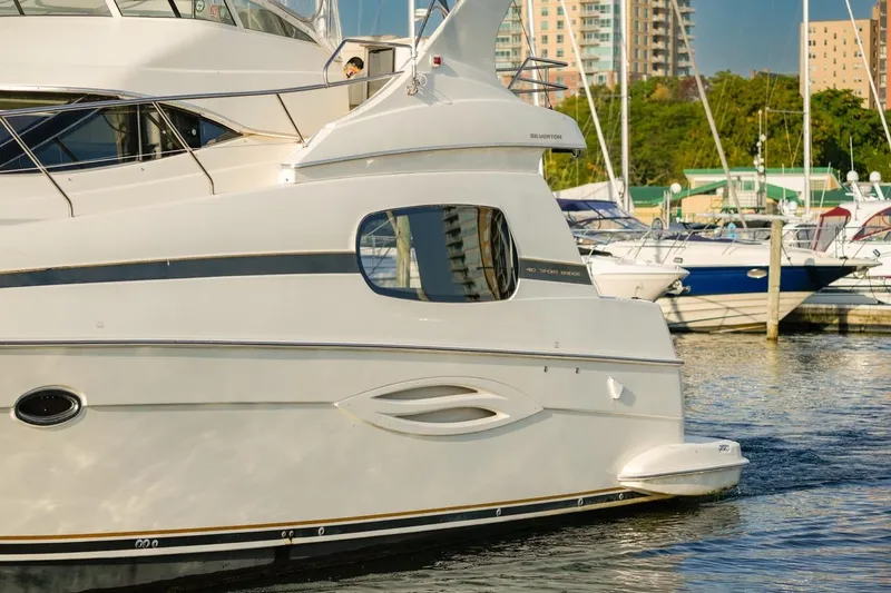 Slide: The Image of 2003 Silverton 410 Sport Bridge yacht docked in a marina with cityscape background. - 11