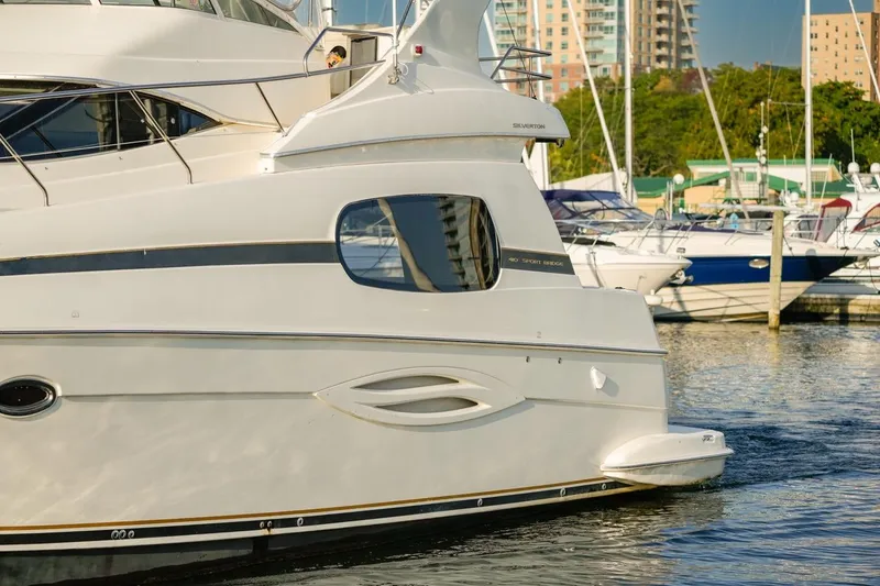 Slide: The Image of 2003 Silverton 410 Sport Bridge yacht docked at marina with cityscape background. - 12