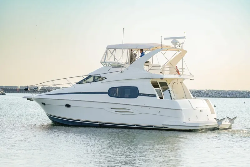 Slide: The Image of 2003 Silverton 410 Sport Bridge yacht cruising on calm waters at sunset. - 15