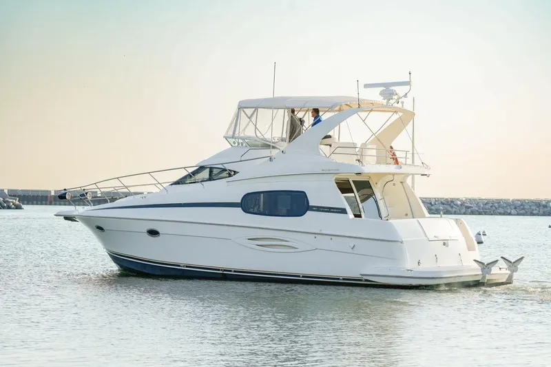 Slide: The Image of 2003 Silverton 410 Sport Bridge yacht cruising on calm waters. - 16