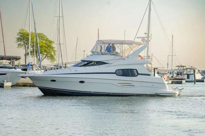 Slide: The Image of 2003 Silverton 410 Sport Bridge yacht docked in a marina, surrounded by sailboats. - 20