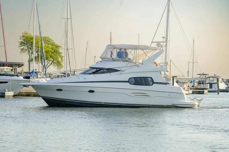 Slide: The Image of 2003 Silverton 410 Sport Bridge yacht docked in a marina with sailboats. - 21