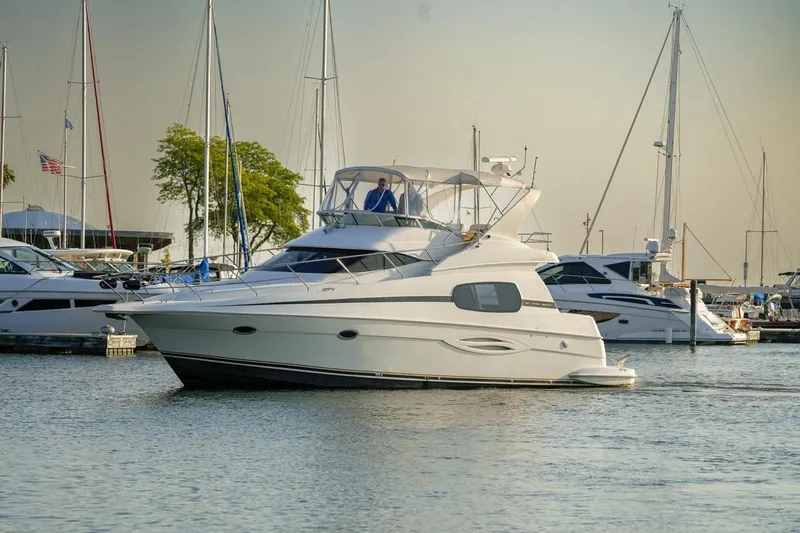 Slide: The Image of 2003 Silverton 410 Sport Bridge yacht docked in a marina with sailboats. - 23