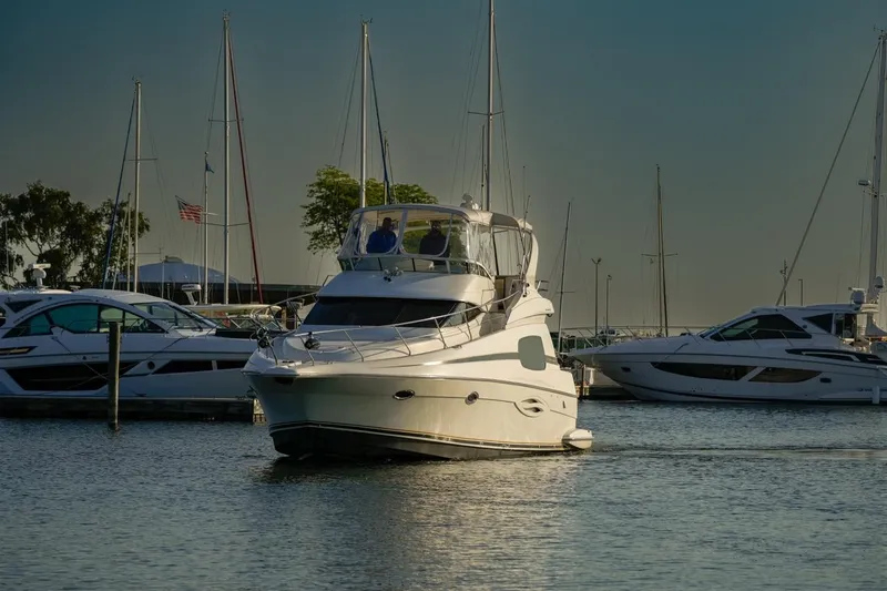 Slide: The Image of 2003 Silverton 410 Sport Bridge yacht docked in a marina with sailboats. - 28