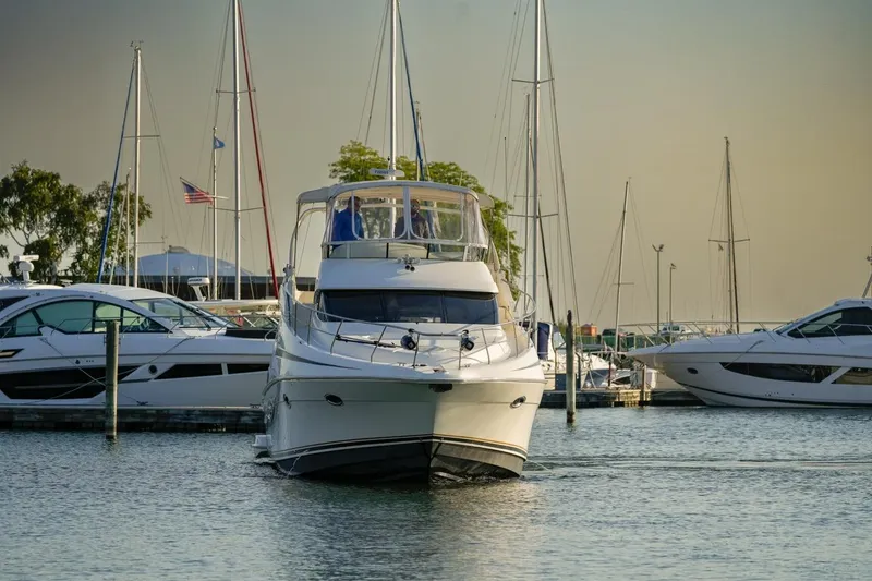 Slide: The Image of 2003 Silverton 410 Sport Bridge yacht docked in a marina with sailboats. - 31