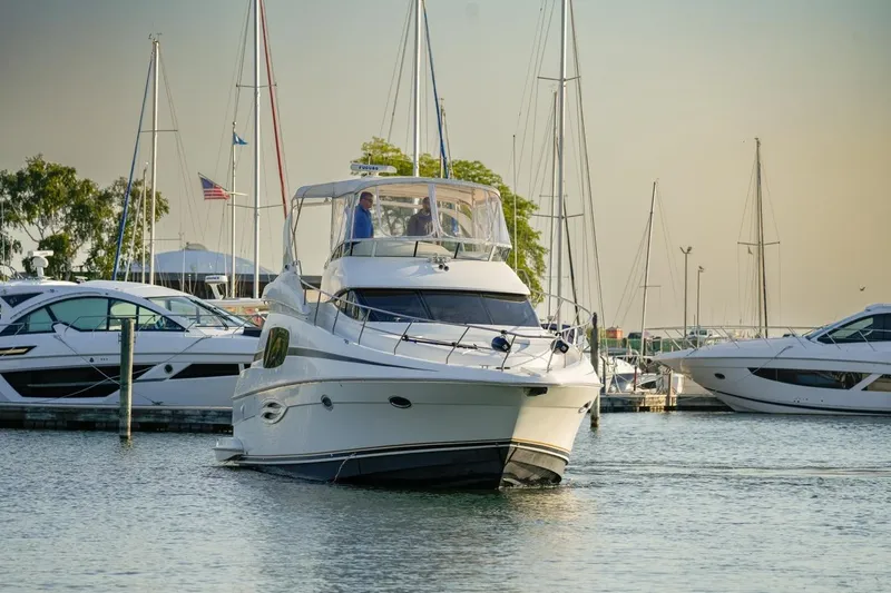 Slide: The Image of 2003 Silverton 410 Sport Bridge yacht docked in a marina with sailboats. - 32