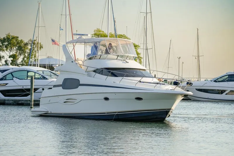Slide: The Image of 2003 Silverton 410 Sport Bridge yacht docked in a marina, surrounded by other boats. - 38