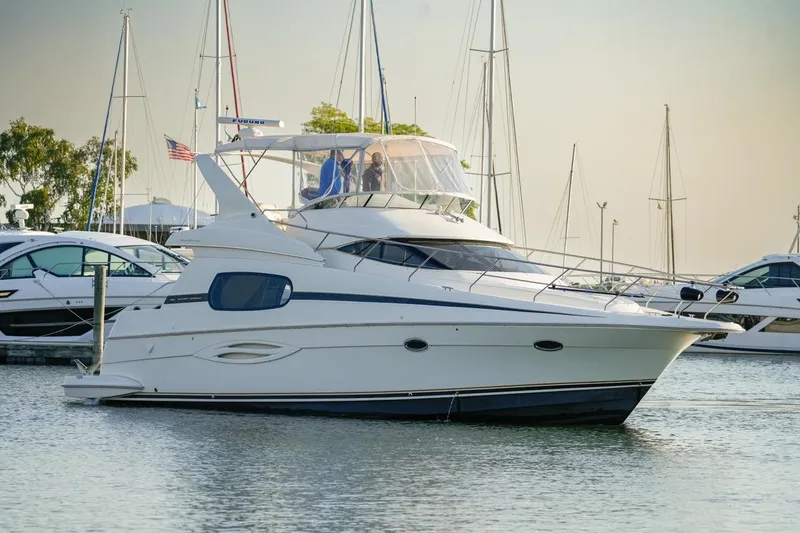 Slide: The Image of 2003 Silverton 410 Sport Bridge yacht docked in a marina, surrounded by sailboats. - 40
