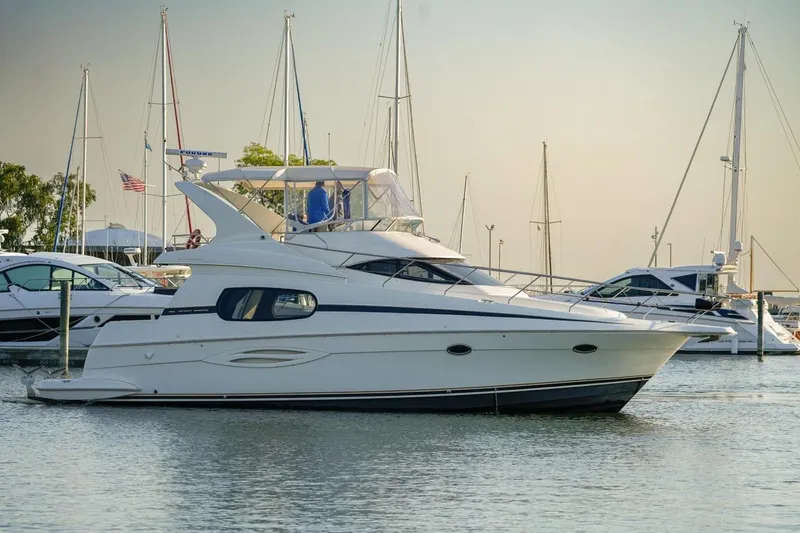 Slide: The Image of 2003 Silverton 410 Sport Bridge yacht docked in a marina, surrounded by sailboats. - 41
