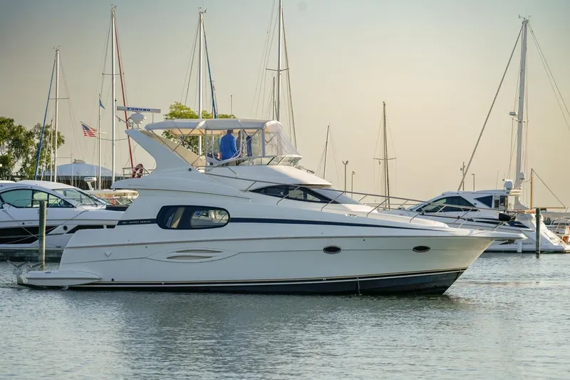 Slide: The Image of 2003 Silverton 410 Sport Bridge yacht docked in a marina with sailboats. - 42